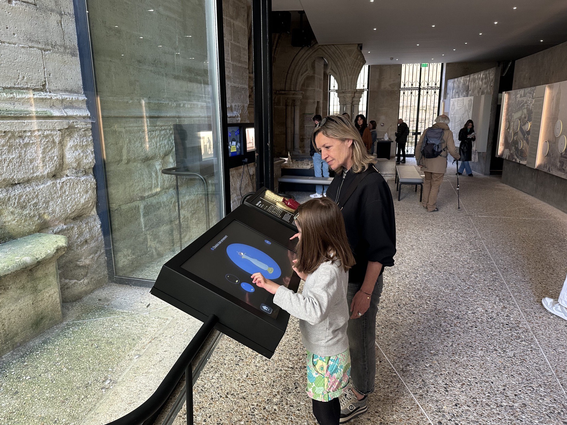 Visiteurs devant un dispositif interactif de la Basilique Saint-Denis